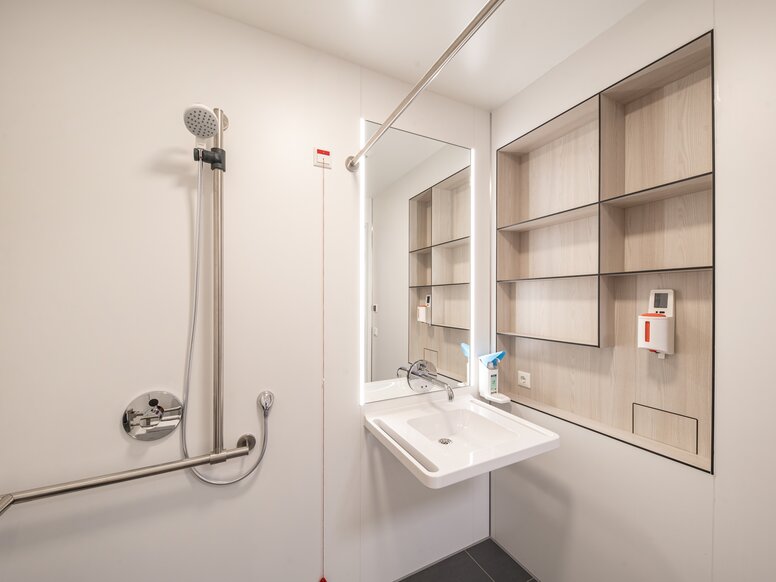 HEWI KARMIN patiëntenbadkamer Patiëntenbadkamer met wastafel en doucheruimte uitgerust met een wastafel en een douchehouder in roestvrij staal